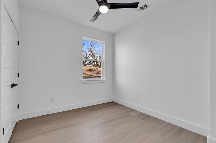 Unfurnished room with ceiling fan and light hardwood / wood-style flooring