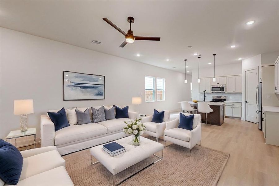 Living room featuring ceiling fan, sink, and light hardwood / wood-style floors