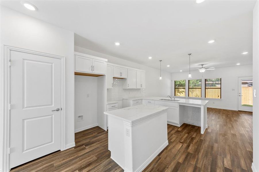 Kitchen featuring hanging light fixtures, white cabinetry, dark hardwood / wood-style floors, and ceiling fan