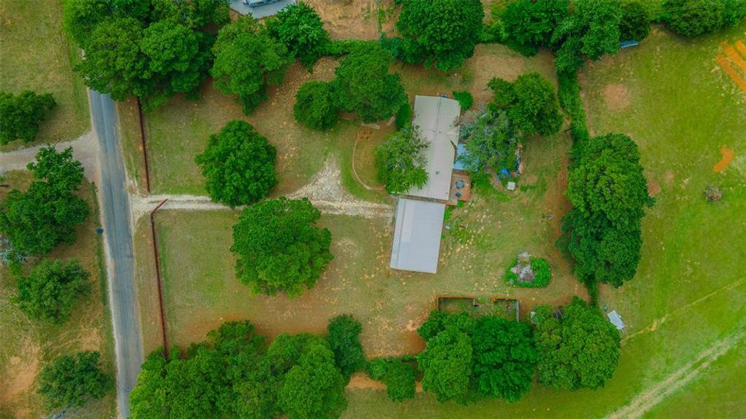 Aerial view highlighting the home's acreage, mature trees, workshop, and peaceful rural setting. Aerial view highlighting the home's acreage, mature trees, workshop, and peaceful rural setting.