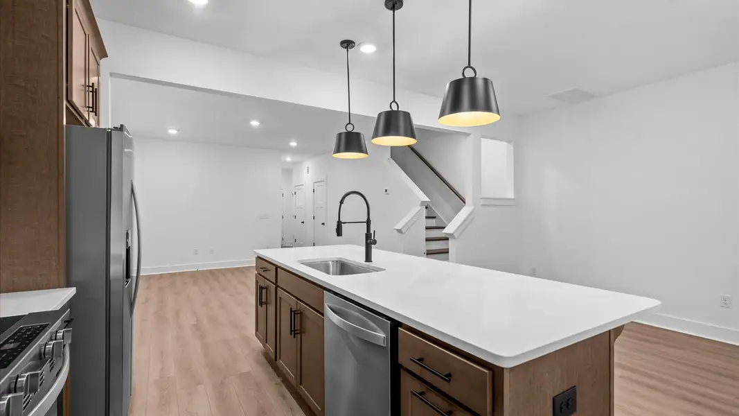 Highly skilled craftsmanship shines in this modern kitchen with pendant lighting and a central island focal point Highly skilled craftsmanship shines in this modern kitchen with pendant lighting and a central island focal point