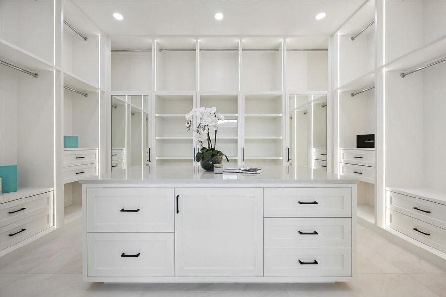 Dream custom walk-in closet with oversized island, built-in drawers, and open shelving, the epitome of organization. Dream custom walk-in closet with oversized island, built-in drawers, and open shelving, the epitome of organization.