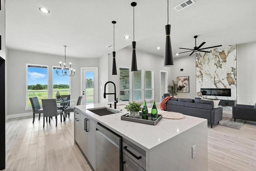 Kitchen featuring stainless steel dishwasher, a chandelier, ceiling fan, light wood finished floors, and recessed lighting Kitchen featuring stainless steel dishwasher, a chandelier, ceiling fan, light wood finished floors, and recessed lighting
