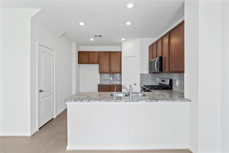 This spacious kitchen has it all—ample storage, generous counter space, and a layout that truly makes it the heart of the home.