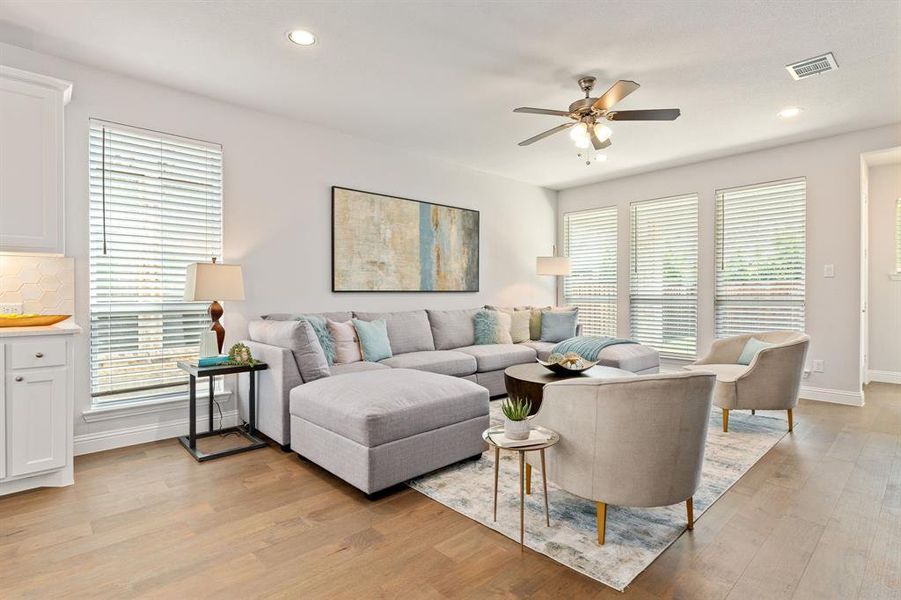 Living room featuring a wealth of natural light, ceiling fan, and light hardwood flooring