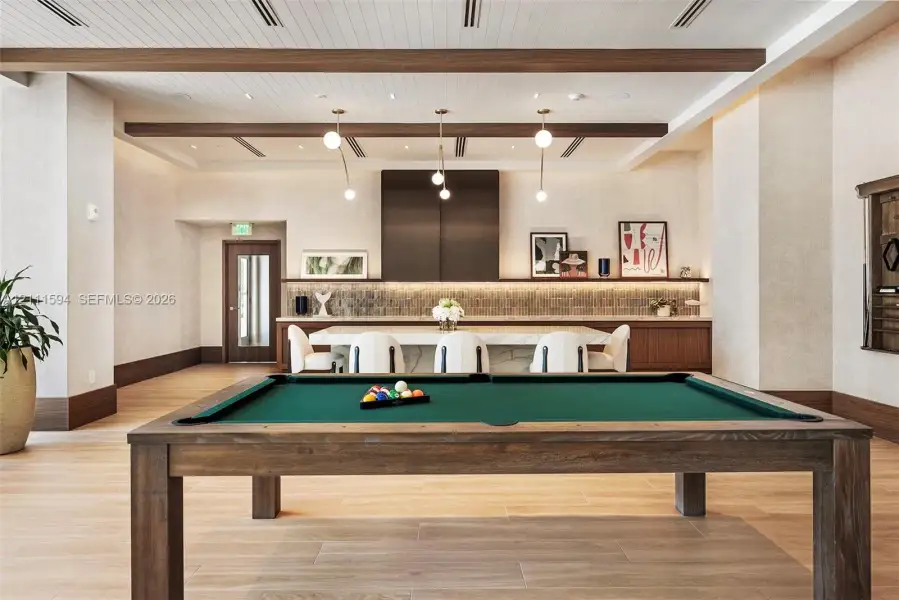 Wood-finish flooring, exposed ceiling beams, stone-top island with integrated cabinetry, tile backsplash, and recessed lighting Wood-finish flooring, exposed ceiling beams, stone-top island with integrated cabinetry, tile backsplash, and recessed lighting