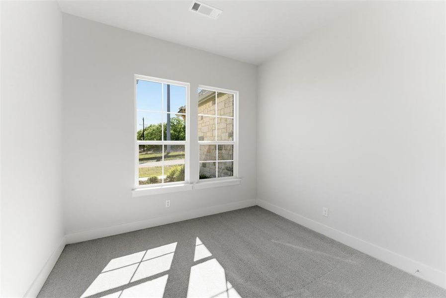 Spare room with light colored carpet and baseboards