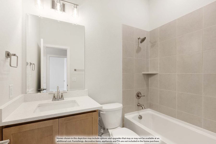 Bathroom with wood vanity, white countertop, large mirror, and tiled shower-tub combo with brushed nickel fixtures Bathroom with wood vanity, white countertop, large mirror, and tiled shower-tub combo with brushed nickel fixtures