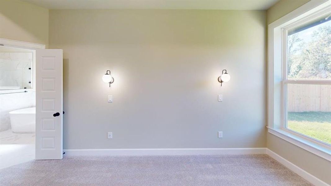 Spare room featuring light colored carpet and baseboards