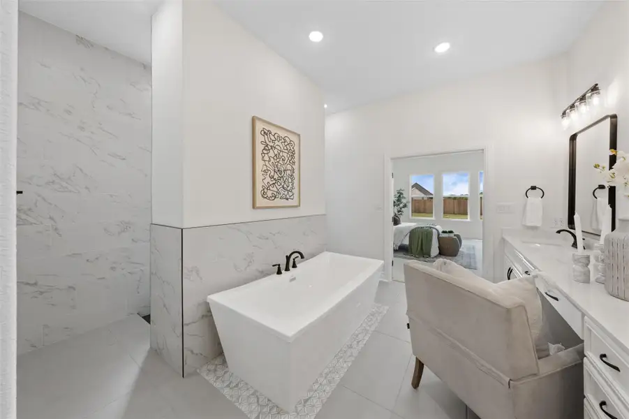 Ensuite bathroom with tile walls, double vanity, a freestanding tub, recessed lighting, and light tile patterned flooring Ensuite bathroom with tile walls, double vanity, a freestanding tub, recessed lighting, and light tile patterned flooring
