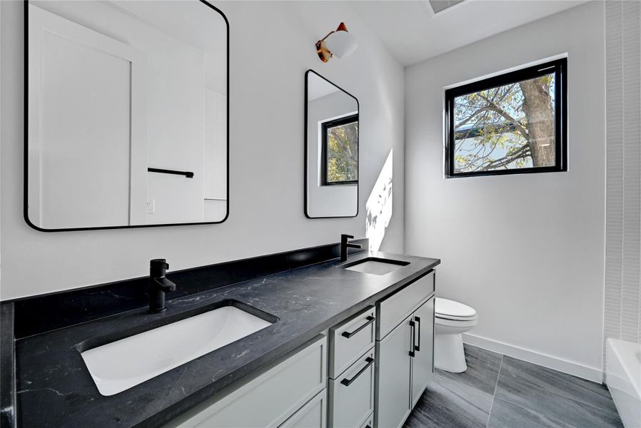 Bathroom featuring double vanity and toilet