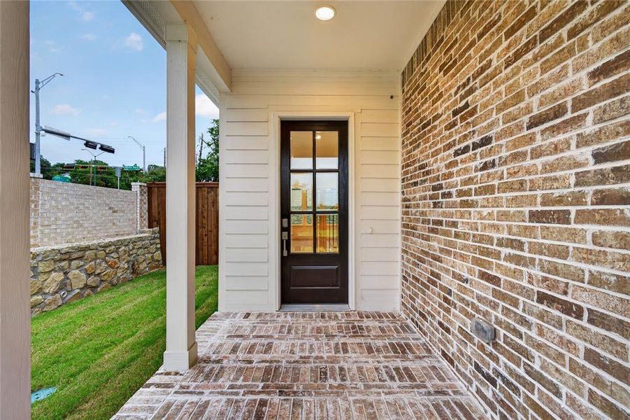 Inviting front entry featuring a glass-paneled door, horizontal siding, and a brick exterior Inviting front entry featuring a glass-paneled door, horizontal siding, and a brick exterior