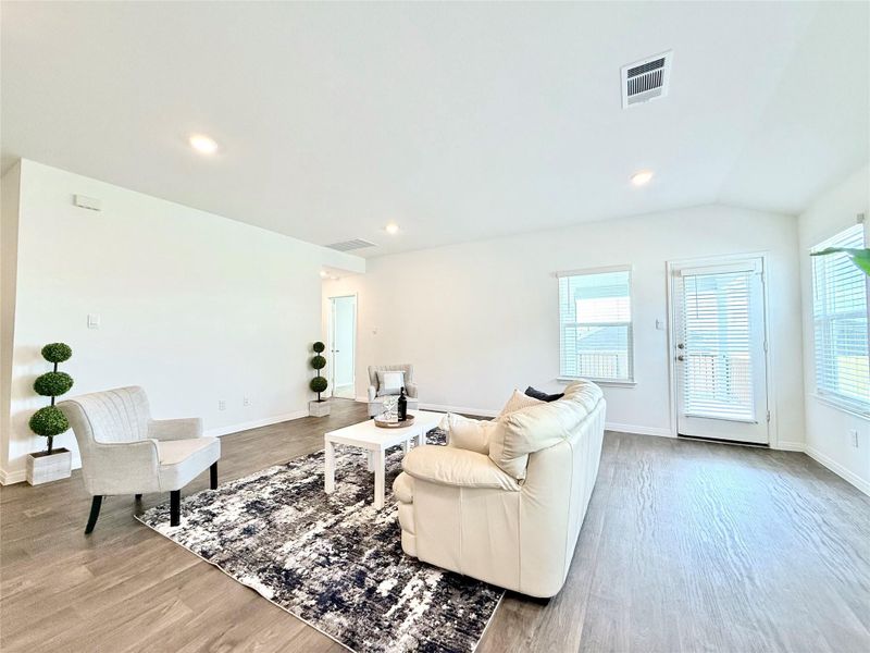 Living room featuring light wood-style flooring, recessed lighting, and lofted ceiling Living room featuring light wood-style flooring, recessed lighting, and lofted ceiling