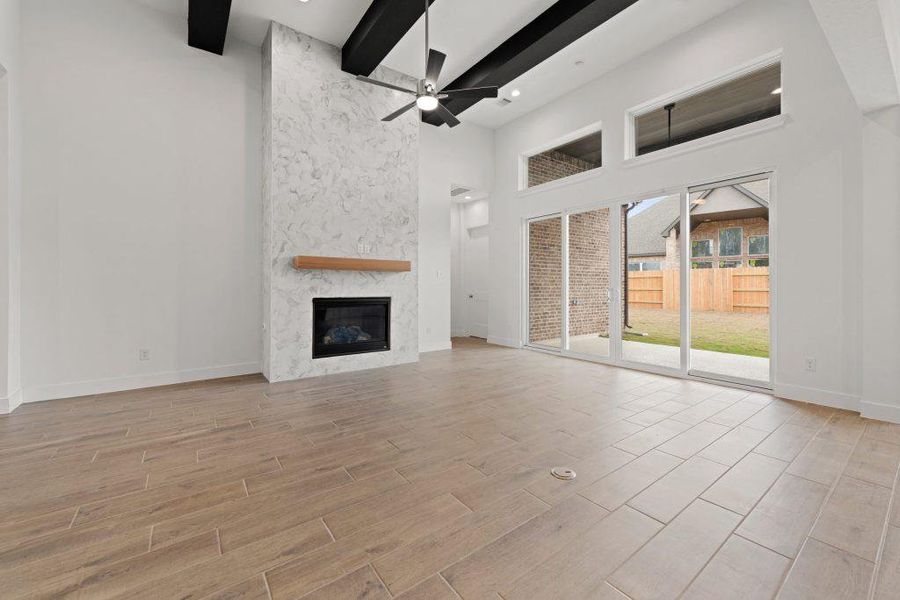 A spacious great room offers high ceilings and a cozy fireplace with direct access to the private yard.