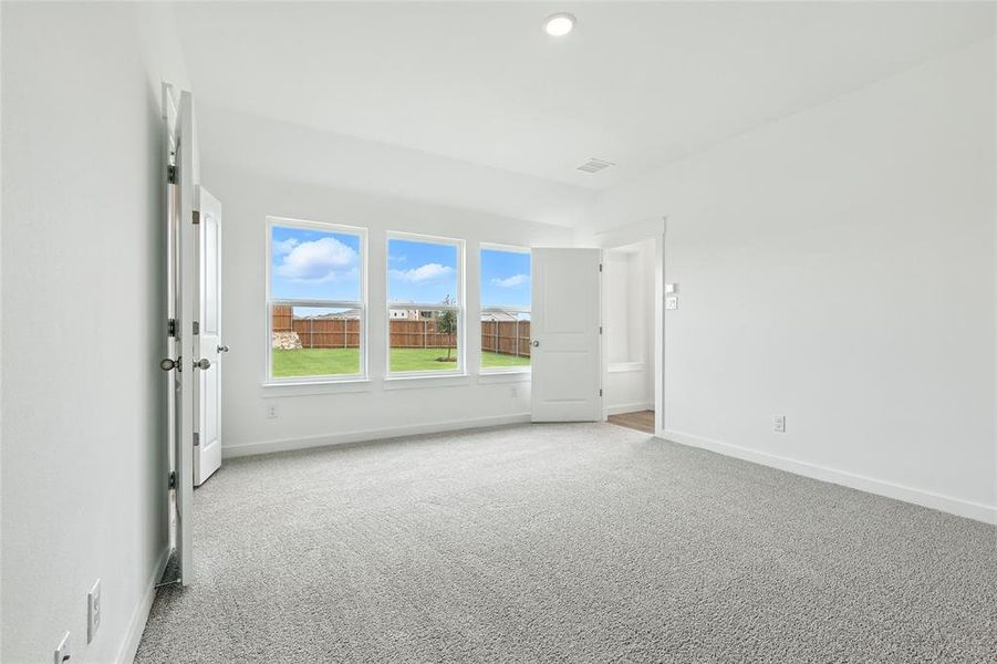 Spare room with light colored carpet and baseboards