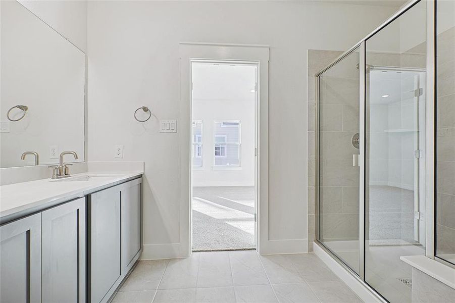 Full bath with vanity, a shower stall, and tile patterned floors