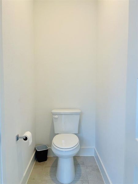 Bathroom featuring light tile patterned flooring and baseboards Bathroom featuring light tile patterned flooring and baseboards