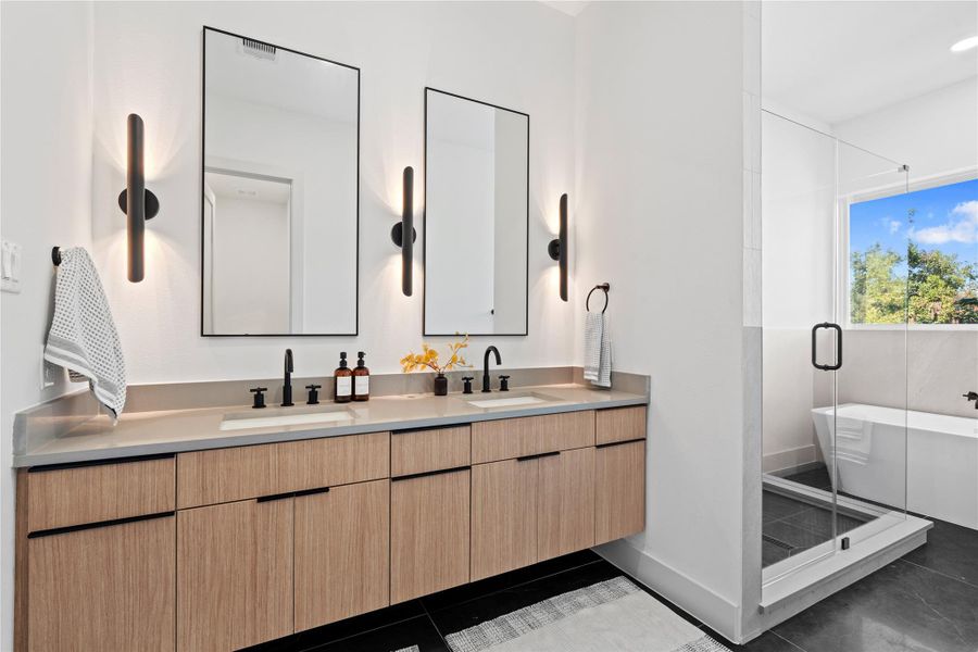 The primary ensuite continues the home’s warm palette, featuring floating vanities, ample storage & expansive counter space. The primary ensuite continues the home’s warm palette, featuring floating vanities, ample storage & expansive counter space.