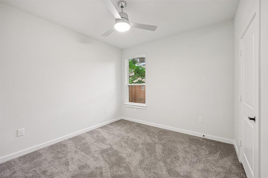 Carpeted spare room with baseboards and a ceiling fan Carpeted spare room with baseboards and a ceiling fan