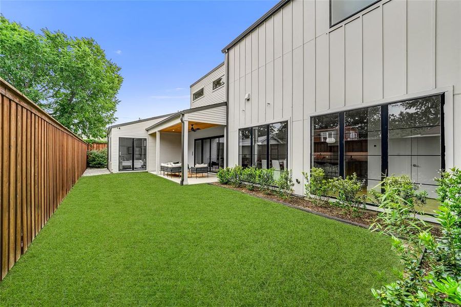 Expansive green lawn with a wooden fence