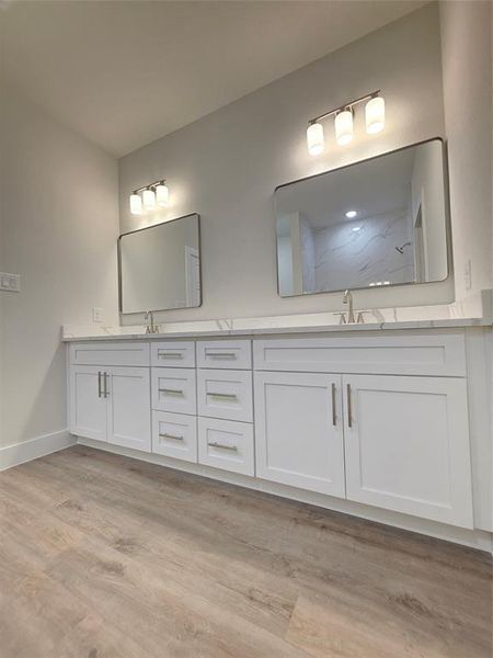 Master/ primary bathroom and designer mirrors, luxury vinyl flooring, double vanity sinks, white shaker cabinets with self closing and hardware.