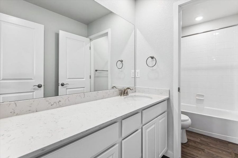 A bathroom with a tub sink and toilet.