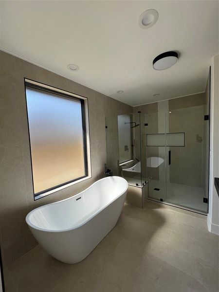 Full bathroom featuring a freestanding bath and a stall shower