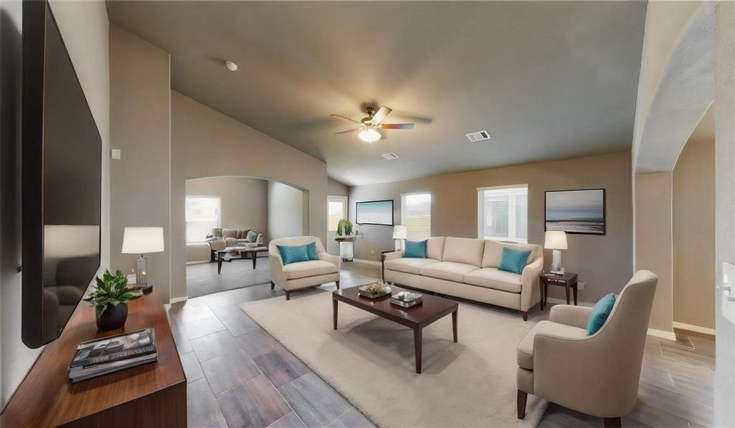 The living room offers a warm and inviting atmosphere with its large windows, contemporary tile flooring, and ample space for versatile furniture arrangements. The open concept design ensures an easy flow between the living area and the adjoining spaces, creating an ideal setting for gatherings. This is a picture of an Elise Floor Plan with another Saratoga Homes.