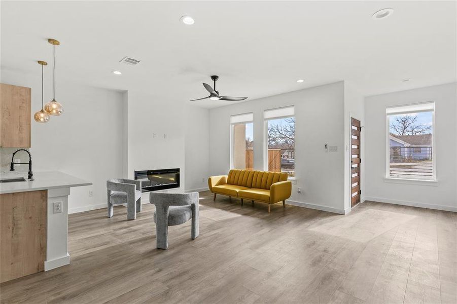 Living room with ceiling fan, sink, and light hardwood / wood-style flooring