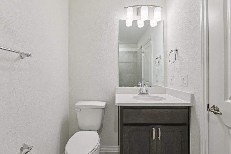 Bathroom featuring vanity and a textured wall