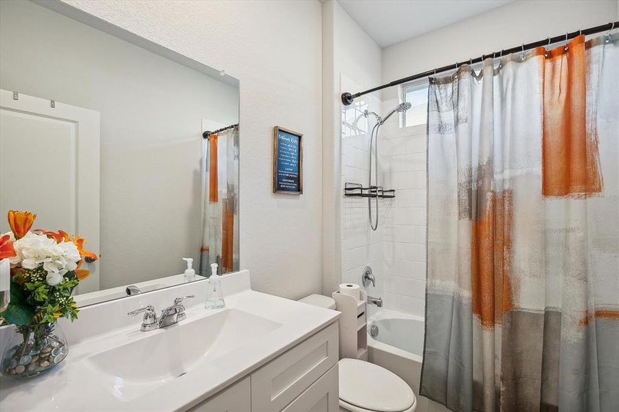 Full bathroom with toilet, vanity, and shower / bath combo Full bathroom with toilet, vanity, and shower / bath combo