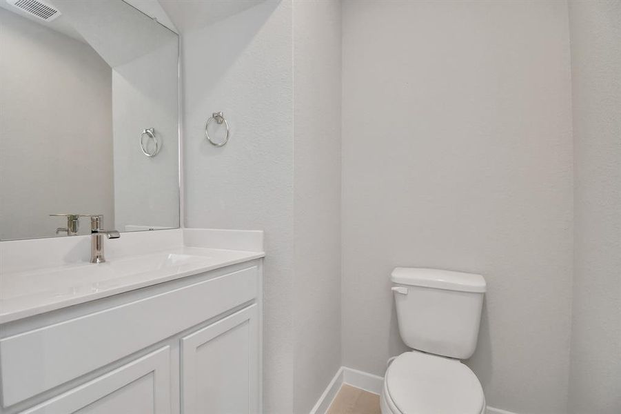 Step into this bright and airy half bath, where a sleek pedestal sink and modern hardware elevate the space with contemporary charm.