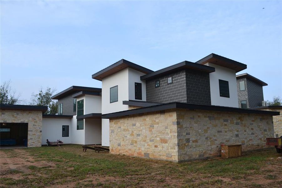 Back of house with stucco siding and stone siding Back of house with stucco siding and stone siding