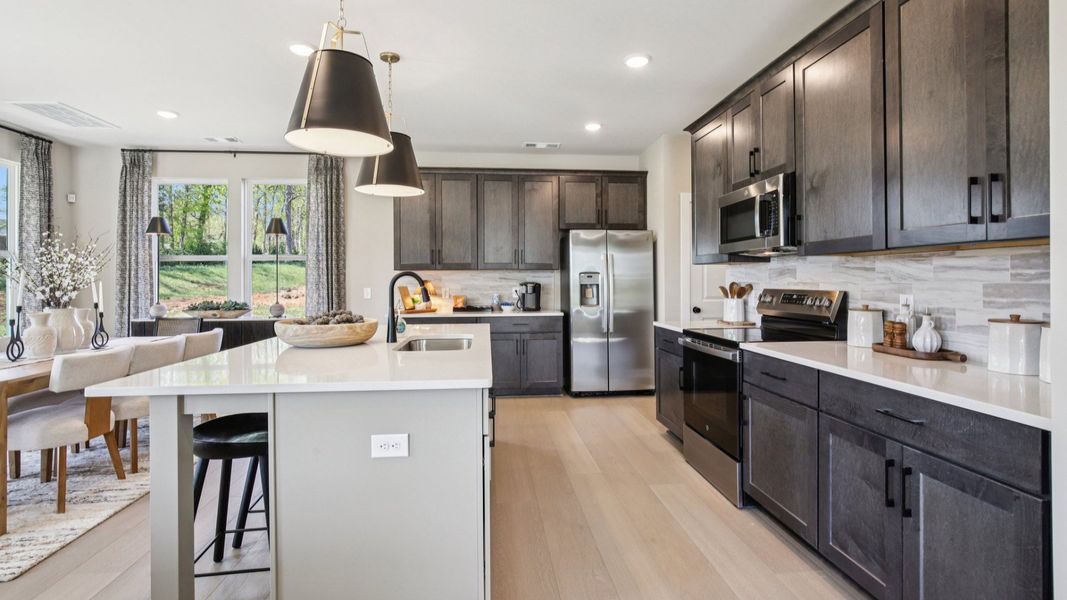 Kitchen with quartz countertops and dark cabinetry
