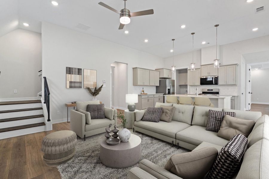 Open-concept living area featuring wood-finish flooring, recessed lighting, and a contemporary ceiling fan Open-concept living area featuring wood-finish flooring, recessed lighting, and a contemporary ceiling fan