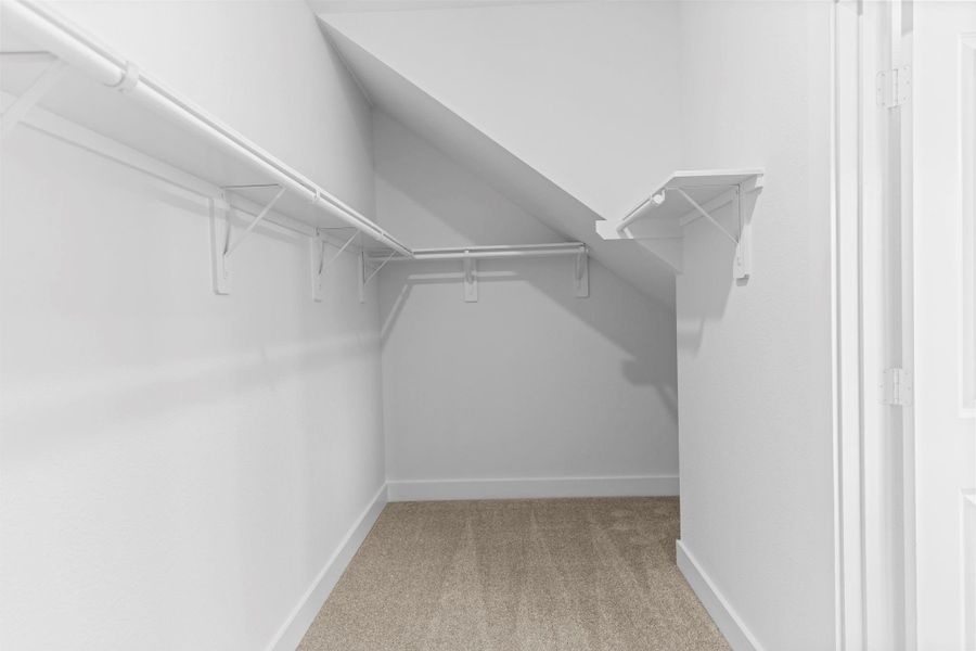 Spacious walk-in closet located within the primary suite offers built-in shelving and ample hanging space for effortless organization. **Image Representative of Plan Only and May Vary as Built**.