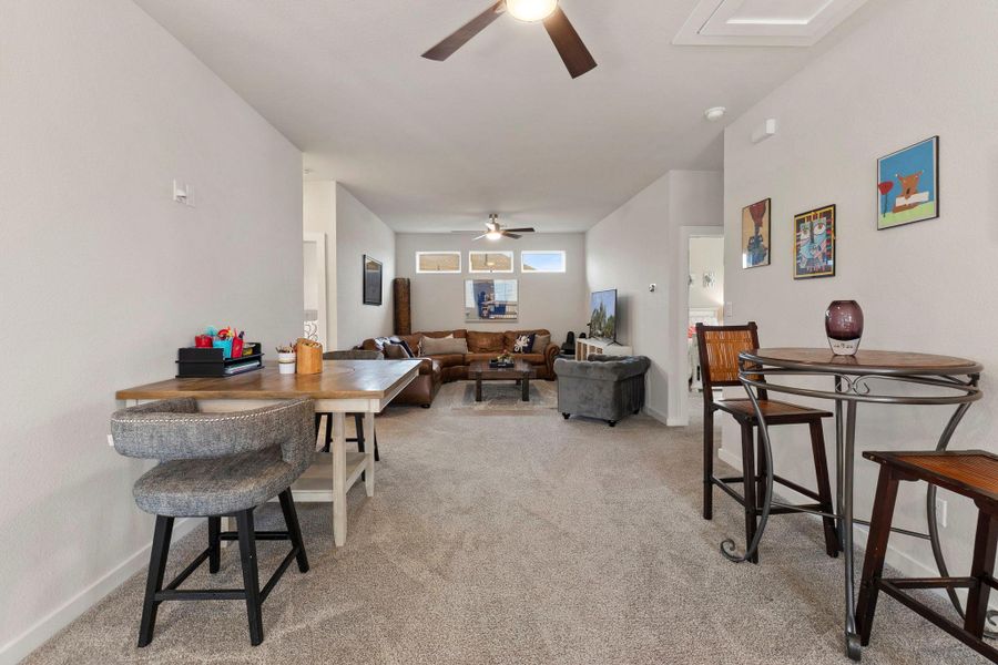 Expansive open-concept living area featuring light-toned carpeting and neutral wall colors