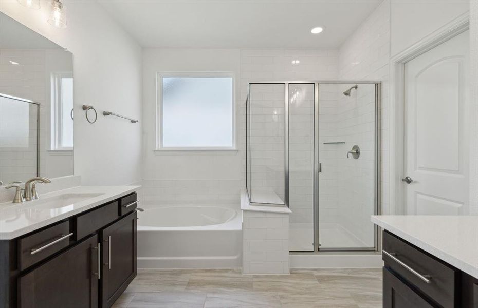 Elegant owner's suite with dual vanity and oversized shower*real home pictured