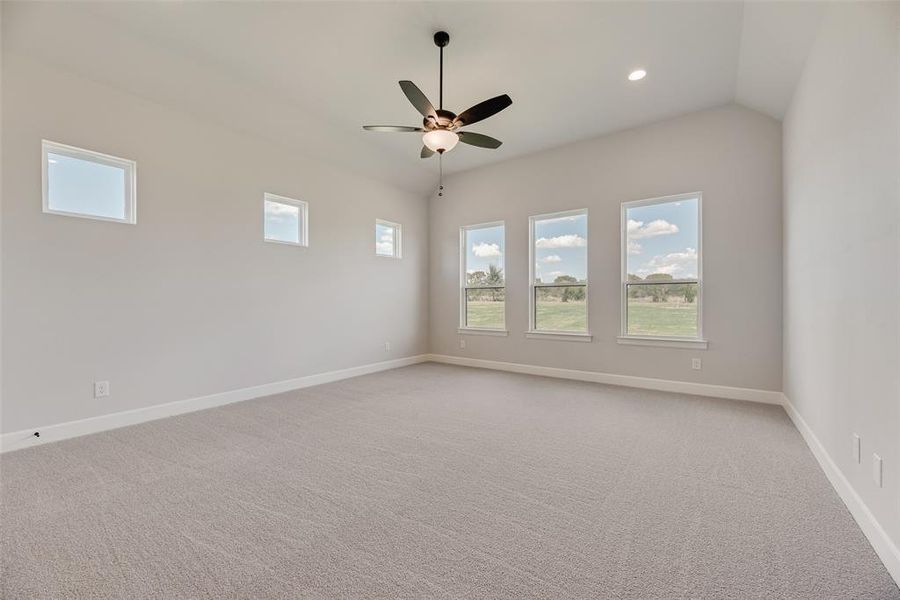Spare room featuring light colored carpet, healthy amount of natural light, recessed lighting, and ceiling fan