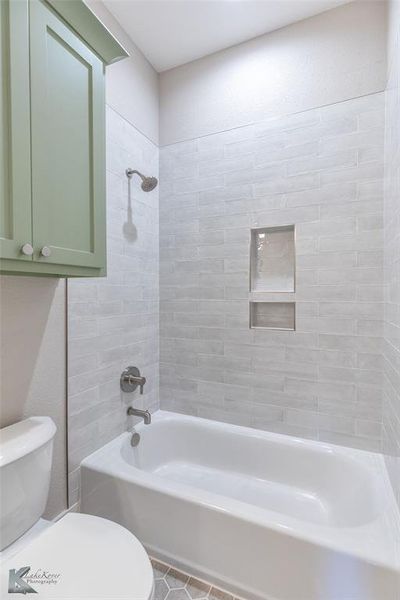 Full bathroom featuring washtub / shower combination and tile patterned flooring