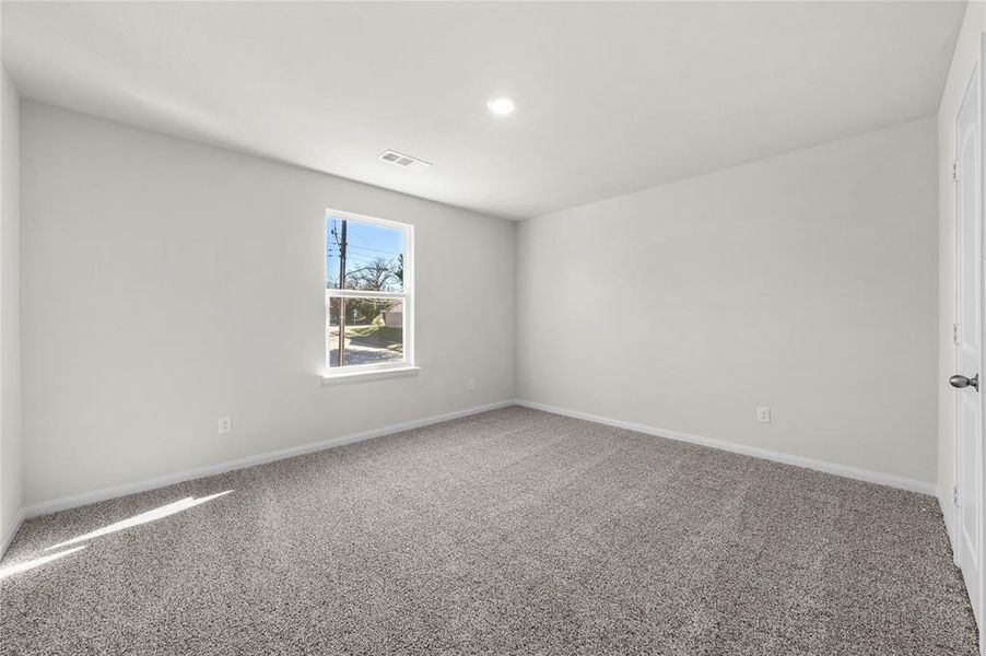 Spare room with carpet floors, visible vents, and baseboards