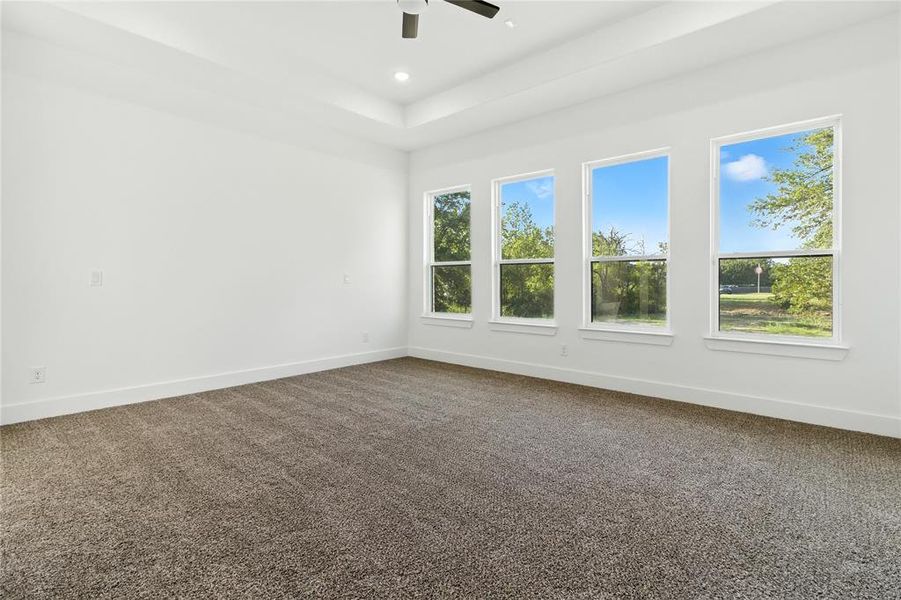 Unfurnished room with dark carpet, a tray ceiling, recessed lighting, and a ceiling fan Unfurnished room with dark carpet, a tray ceiling, recessed lighting, and a ceiling fan