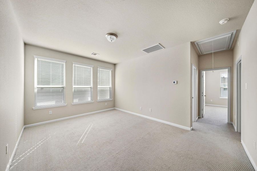 This generous primary bedroom offers an expansive layout, providing ample space for a king-sized bed and additional furniture.