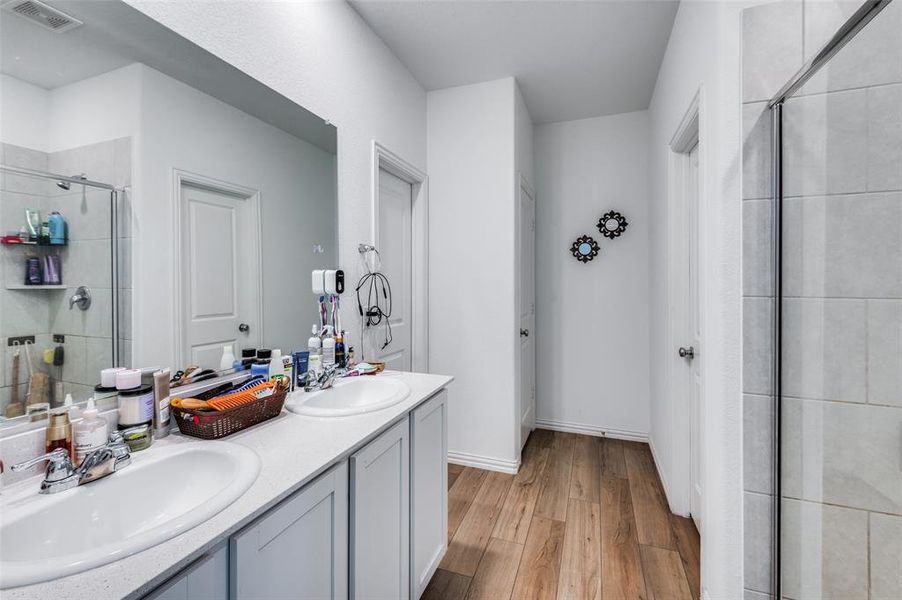 Bathroom featuring vanity, an enclosed shower, and wood-type flooring