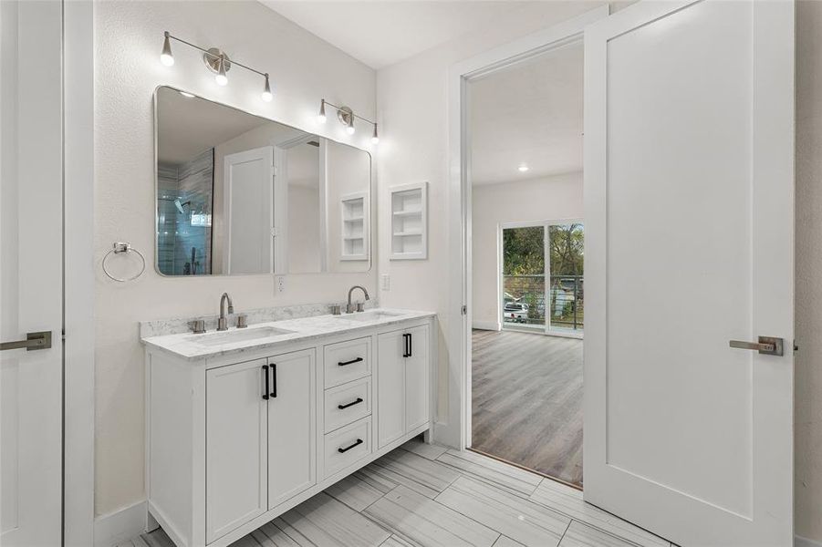 Full bath featuring double vanity, a stall shower, and wood tiled floors Full bath featuring double vanity, a stall shower, and wood tiled floors