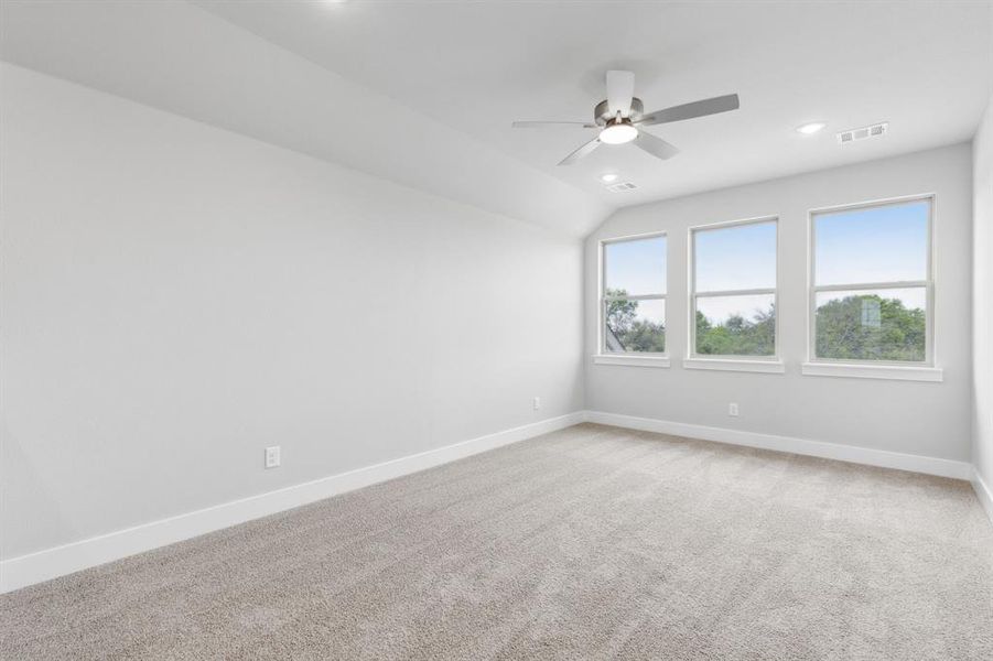 Empty room with recessed lighting, ceiling fan, light carpet, and vaulted ceiling Empty room with recessed lighting, ceiling fan, light carpet, and vaulted ceiling