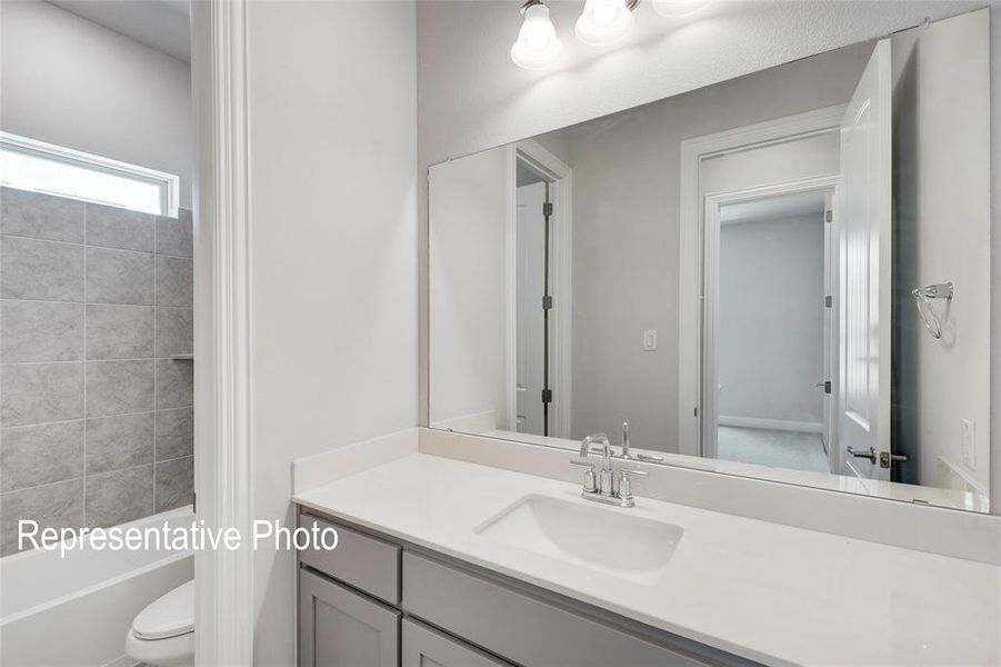 Full bathroom with oversized vanity, shower / bathtub combination, and toilet