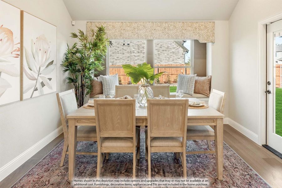 Dining room with light wood table, six chairs, bench seating, large window, and patterned area rug on hardwood floors