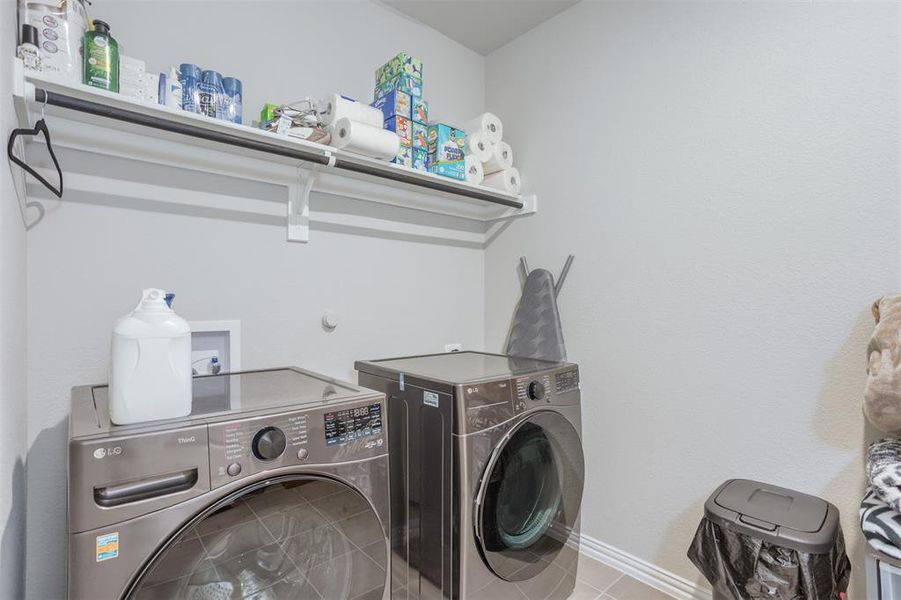 Washroom with separate washer and dryer and tile patterned flooring Washroom with separate washer and dryer and tile patterned flooring