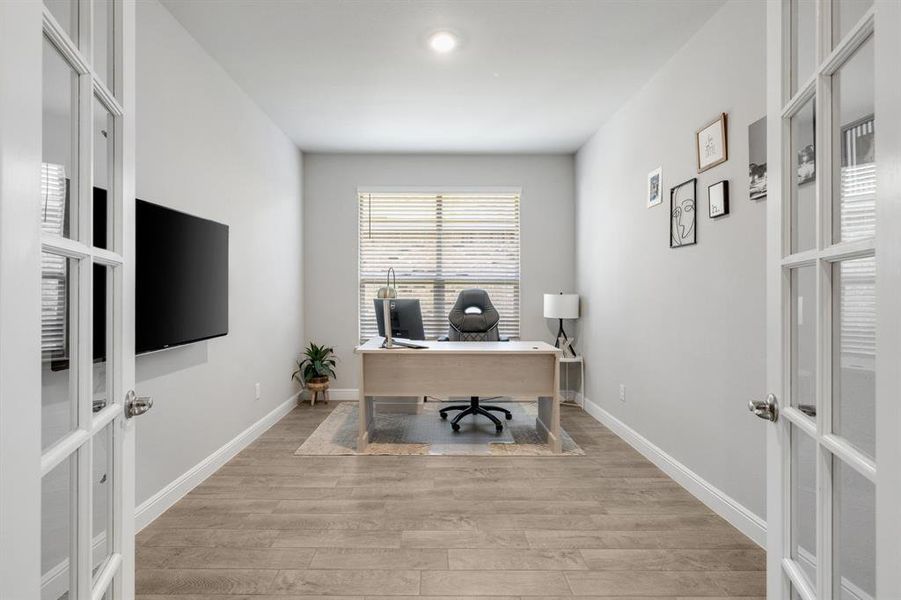 Office space featuring french doors and light wood finished floors